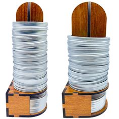 two stacks of silver and wood stacked on top of each other in front of a white background