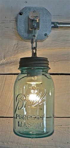 a mason jar hanging from a hook on a wooden wall with the caption below it