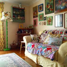 a living room filled with furniture and lots of pictures on the wall above it's couch