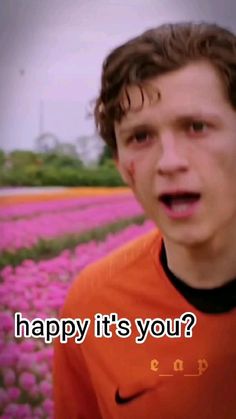 a young man standing in front of a field of flowers with the words happy it's your?