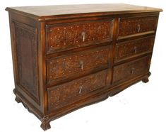 an old wooden dresser with carvings on the top and bottom drawers, against a white background