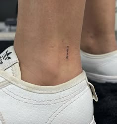 a woman's foot with a small tattoo on the lower part of her ankle