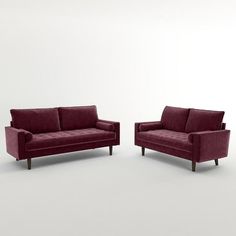 two red couches sitting next to each other on a white floor with no one in it