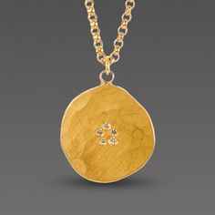 A tiny ring of five white diamonds sparkle in the center of a free-form, organically hammered 22k gold disk. Hangs on 14k gold chain. Pendant measures approximately 1/2 inch diameter. Matte finish. Hand Forged Gold Round Disc Jewelry, Gold Disk Necklace, Wedding Ring Redesign, Capsule Jewelry, Ring Redesign, Gold Chain Pendant, Disk Necklace, Hammered Jewelry, Gold Disc Necklace