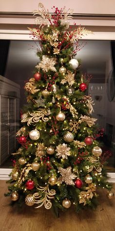 a christmas tree decorated with gold and red ornaments