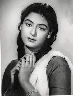 an old black and white photo of a woman with her hands on her chin, looking at the camera