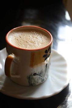 a cup of coffee sitting on top of a white saucer