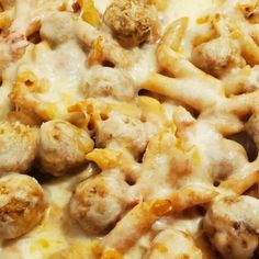 a close up view of some food with cheese and meatballs on it's surface