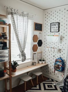 a room with white walls and black and white patterns on the wall, along with wooden shelves