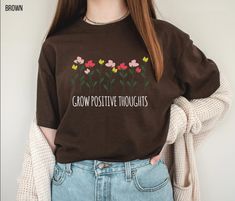 "Grow Positive Thoughts, Botanical Shirt, Cottagecore Aesthetic, Floral Butterfly Shirts, Mental Health Matters, Unisex Graphic Tee PLEASE READ: ❧ Please note that these shirts are unisex size meaning they are not women's fitted shirts. With unisex sizing, these are great for both men and women. For men, order true to size. For women, order true to size or size down by 1 for a more fitted look. ❧ If you are unsure about the size you should order, please refer to the size chart in the pictures. Y Grow Positive Thoughts, Aesthetic Floral, Fitted Shirts, Botanical Shirt, Floral Butterfly