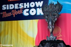 a close up of a trophy on a table with a sign in the background that says sideshow new york con