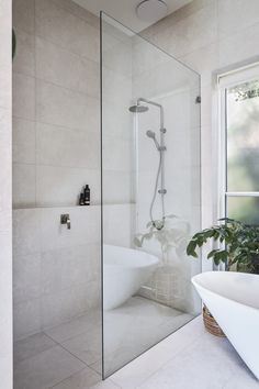 a white bath tub sitting next to a window in a bathroom under a skylight