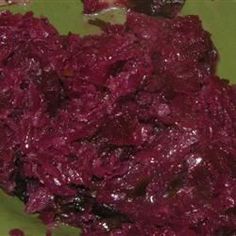 a green plate topped with red food on top of a table