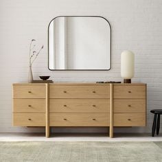 a white brick wall with a wooden dresser and mirror on it's sideboard