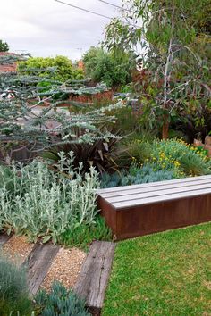 a wooden bench sitting in the middle of a garden