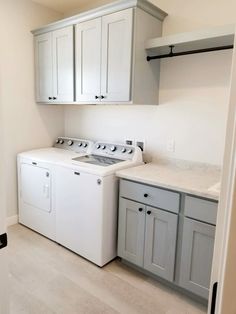 a white washer and dryer in a room with cabinets on either side of the washer