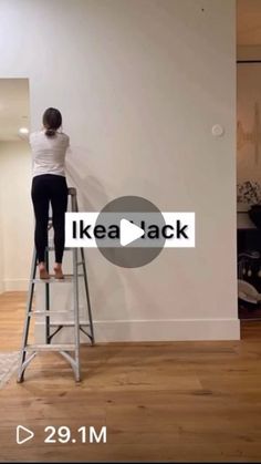 a woman standing on top of a ladder in front of a wall with the words ikea back