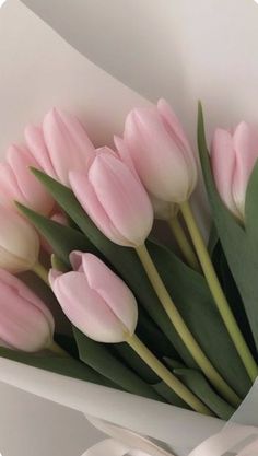 a bouquet of pink tulips in a white vase