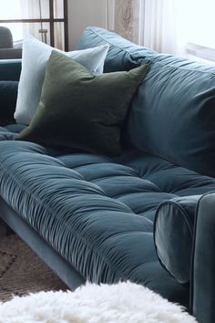 a blue couch with several pillows on it