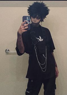 a man with black hair and piercings taking a selfie in front of a mirror