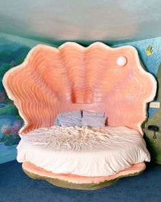 a bed made out of an oyster shell in a room with blue carpet and walls