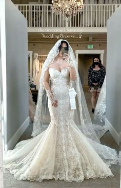 a woman in a wedding dress is taking a selfie with her cell phone while wearing a veil