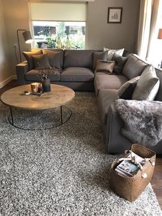 a living room filled with lots of furniture and pillows on top of carpeted flooring