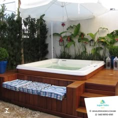 a hot tub sitting on top of a wooden deck next to a planter filled with potted plants