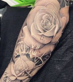 a man's arm with three roses on it