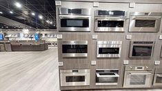 an assortment of ovens and microwaves on display in a store or showroom