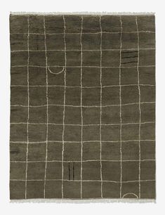 an area rug with squares and lines on the ground, in dark olive green color