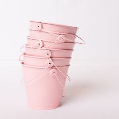 four pink buckets are stacked on top of each other and tied up with string