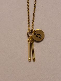 Gold Drumstick Charm Necklace with Initial. Comes on a 20inch gold stainless steel chain. ** We also carry this necklace in silver Please select the letter you would like using the drop-down menu when placing your order.  Please feel free to message us with any questions you may have.   We would be happy to help you.  Thank you so much! Marching Drum, Drummer Gifts, Band Necklace, Music Jewelry, Rock Band, Stainless Steel Chain, Initial Necklace, Rock Bands, Pendant Necklaces