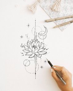 someone is drawing a lotus flower on paper with pencils and watercolng pens