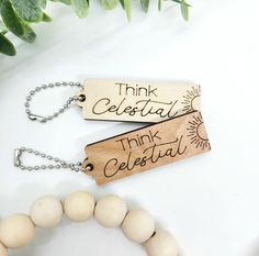 two wooden tags that say think celestial and think celestial