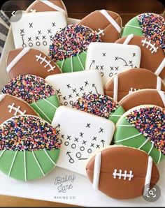 decorated cookies with footballs and sprinkles are on a platter, ready to be eaten