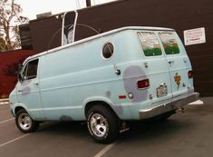 an old blue van parked in a parking lot