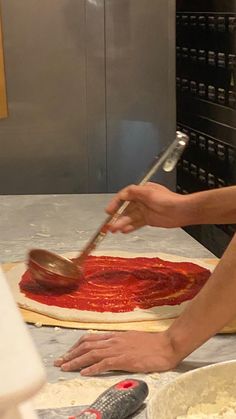 a person is making pizza in the kitchen with a spatula on top of it