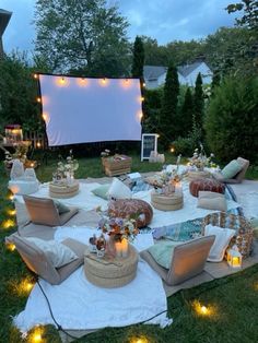 an outdoor movie is set up in the grass with lights on it and several couches