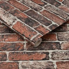 an old brick wall with a roll of tape on it