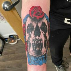 a person with a rose on their head and a skull in the middle of his arm