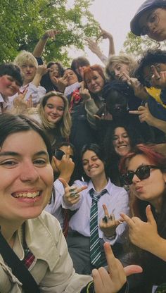 a group of young people posing for a photo with their fingers up in the air