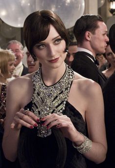 a group of people standing around each other in formal wear and tuxedo hats