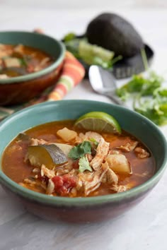 two bowls of chicken tortilla soup on a table