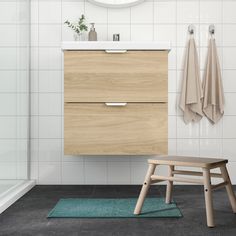 a bathroom with a stool, sink and mirror