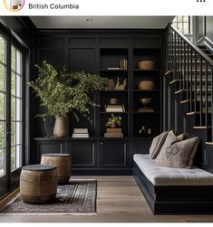 a living room filled with furniture and bookshelves next to a stair case in front of a window