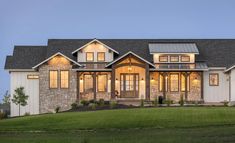 a large house that is lit up in the evening with windows and lights on it