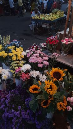 many different types of flowers on display at an outdoor market