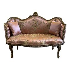 an ornately decorated couch with two pillows on it's back and side ends