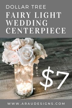 a vase filled with white flowers sitting on top of a wooden table next to a sign that says dollar tree fairy light wedding centerpiece